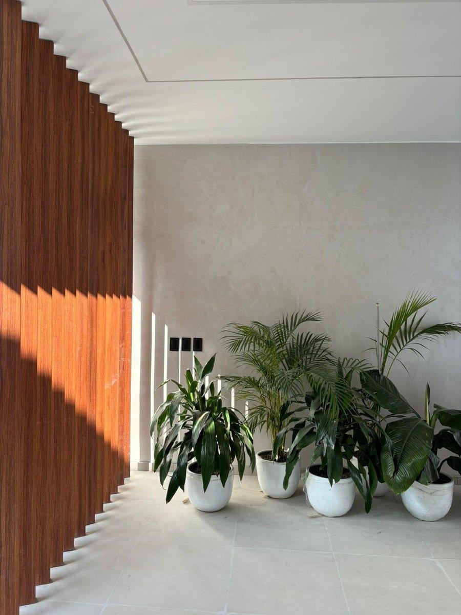 Interior de un proyecto Punto Medio: revestimiento de listones de madera y vegetación natural